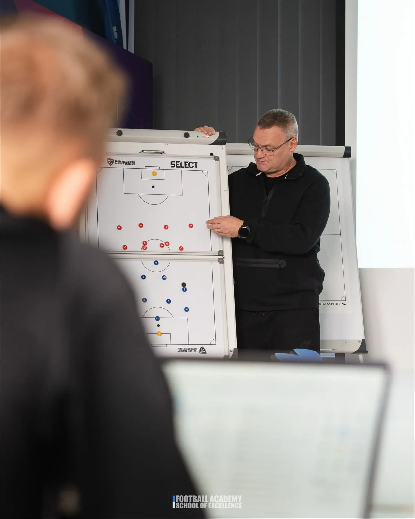 Trener przy magnetycznej tablicy taktycznej podczas zajęć FASE Coaching